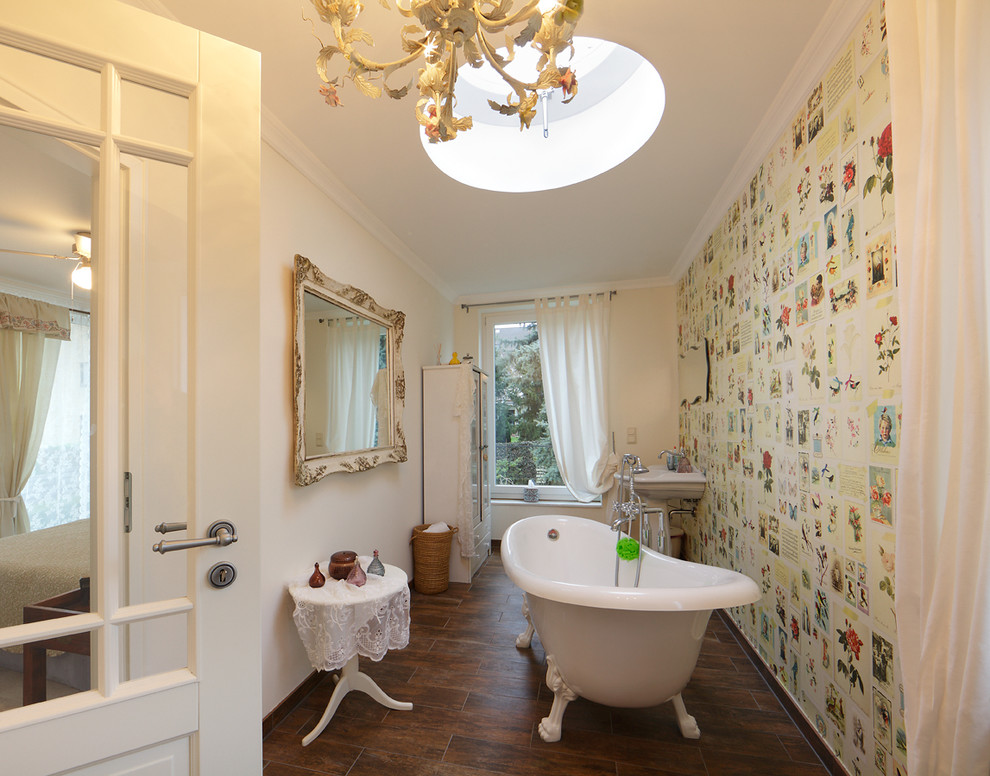 Eklektisches Badezimmer mit Sockelwaschbecken, Löwenfuß-Badewanne, bunten Wänden und dunklem Holzboden in Köln