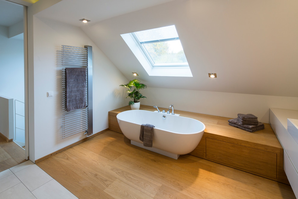 Стильный дизайн: ванная комната среднего размера в современном стиле с накладной ванной, белыми стенами и светлым паркетным полом - последний тренд