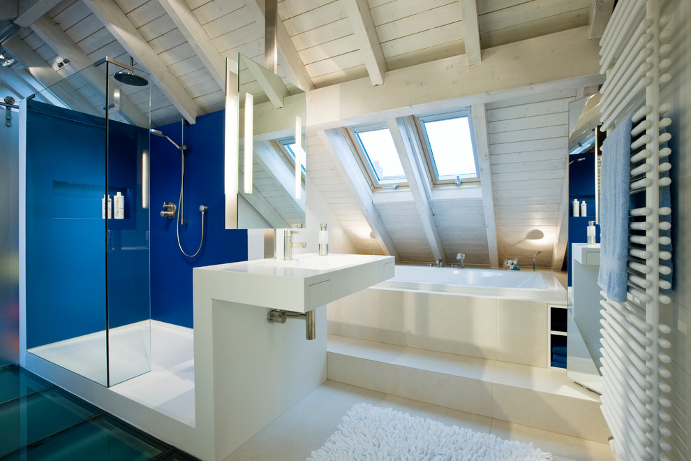 Foto de cuarto de baño principal actual de tamaño medio con bañera encastrada, paredes azules, lavabo integrado y ducha abierta