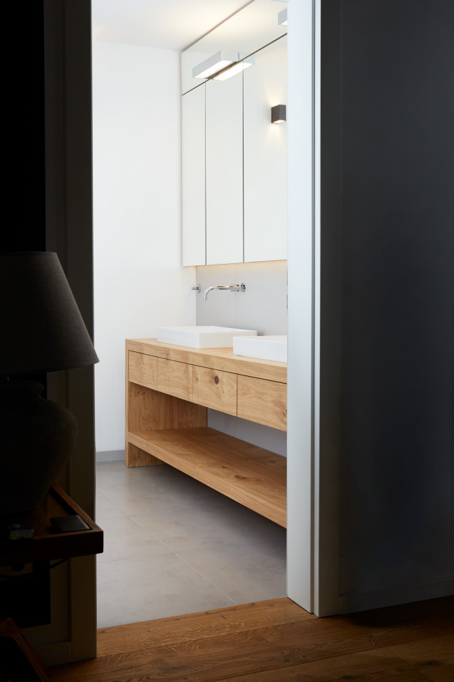 Mittelgroßes Modernes Badezimmer En Suite mit flächenbündigen Schrankfronten und freistehendem Waschtisch in München