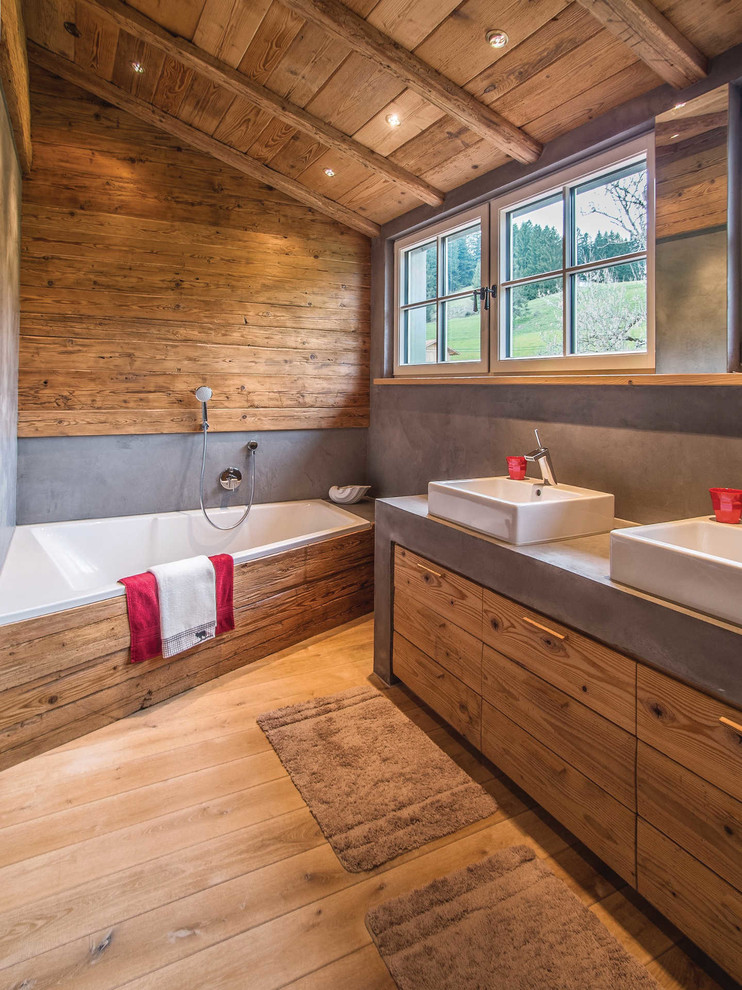 Idéer för mellanstora rustika en-suite badrum, med släta luckor, skåp i mellenmörkt trä, en dusch/badkar-kombination, ljust trägolv, ett fristående handfat, beiget golv, ett badkar i en alkov och grå väggar
