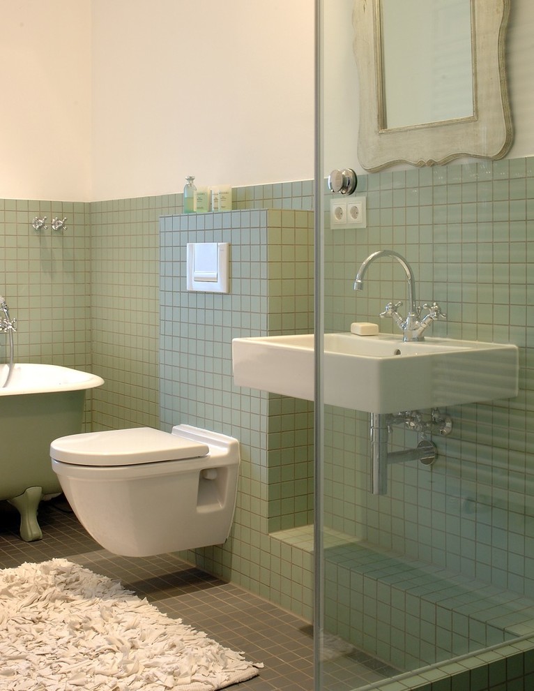 На фото: маленькая ванная комната в современном стиле с ванной на ножках, инсталляцией, зеленой плиткой, керамической плиткой, белыми стенами, полом из керамической плитки, душевой кабиной, подвесной раковиной и зеленым полом для на участке и в саду