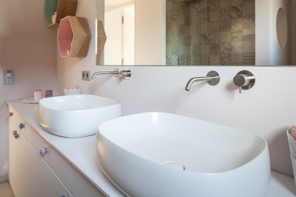 Modern inredning av ett mellanstort badrum, med öppna hyllor, vita skåp, ett platsbyggt badkar, en kantlös dusch, en vägghängd toalettstol, blå kakel, keramikplattor, grå väggar, ljust trägolv, ett väggmonterat handfat, bänkskiva i betong, brunt golv och med dusch som är öppen