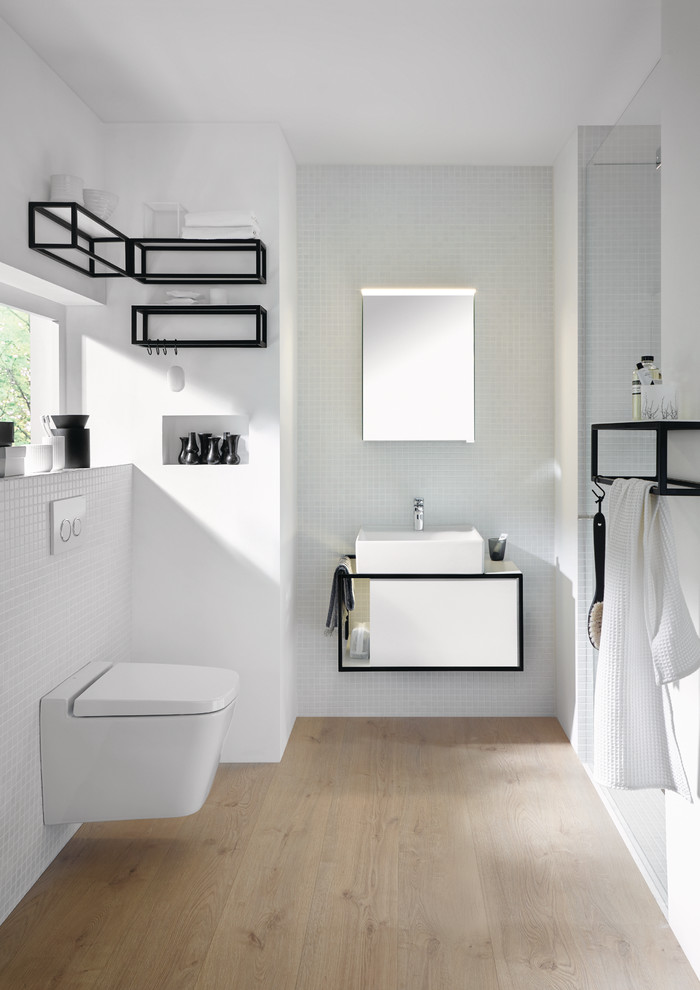 Ejemplo de cuarto de baño contemporáneo pequeño con armarios con paneles lisos, puertas de armario blancas, sanitario de pared y lavabo sobreencimera
