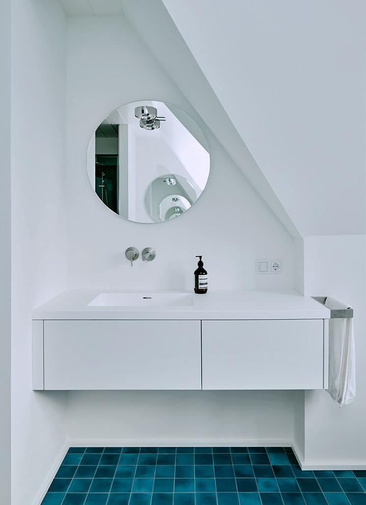 Mittelgroßes Modernes Badezimmer mit flächenbündigen Schrankfronten, weißen Schränken, blauen Fliesen, Zementfliesen, weißer Wandfarbe und integriertem Waschbecken in Sonstige