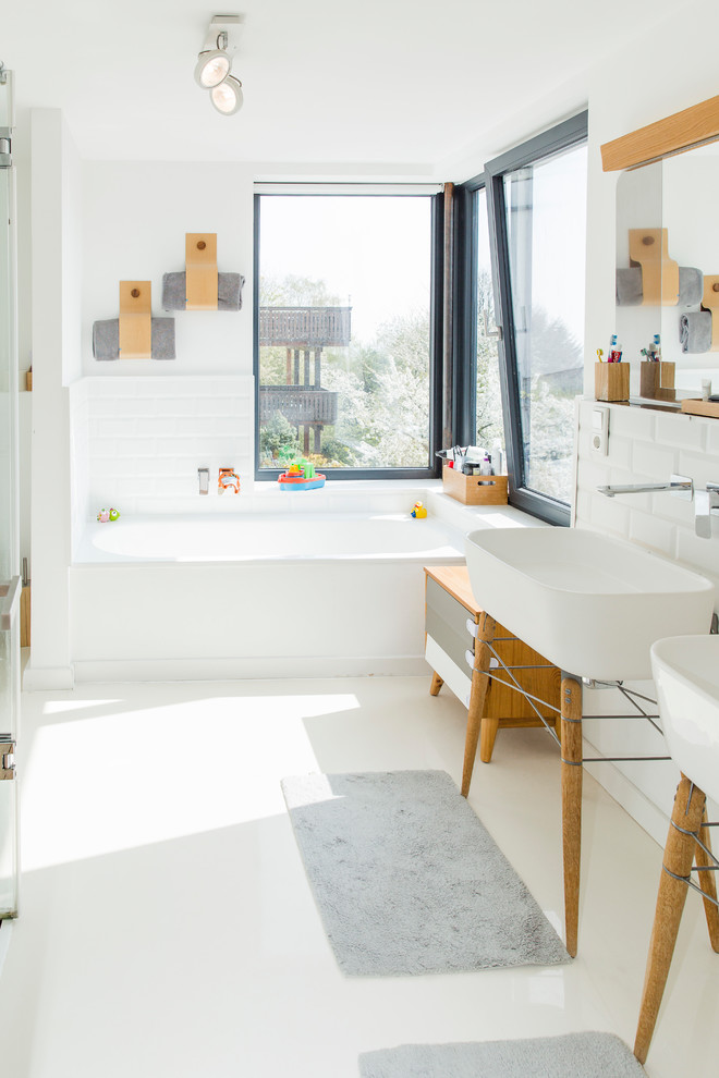 Свежая идея для дизайна: ванная комната среднего размера в скандинавском стиле с накладной ванной, душем над ванной, белой плиткой, плиткой кабанчик, белыми стенами, душевой кабиной, консольной раковиной, столешницей из искусственного камня и белым полом - отличное фото интерьера
