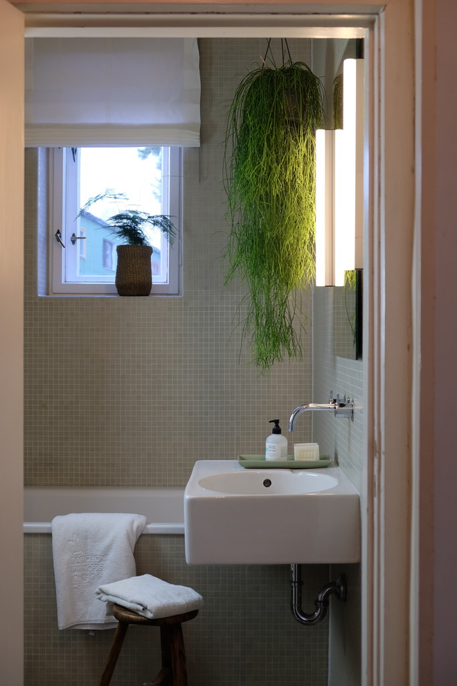 Imagen de cuarto de baño infantil actual pequeño con baldosas y/o azulejos beige, baldosas y/o azulejos en mosaico, lavabo suspendido, bañera encastrada, combinación de ducha y bañera, sanitario de pared, suelo de terrazo, suelo gris y ducha con cortina