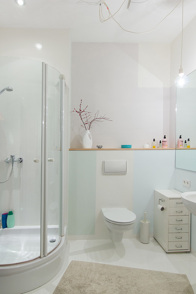 Inspiration for a small contemporary shower room bathroom in Berlin with flat-panel cabinets, white cabinets, a corner shower, a wall mounted toilet, white walls, ceramic flooring, a wall-mounted sink, white floors and a hinged door.