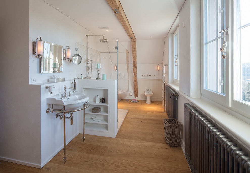 Пример оригинального дизайна: ванная комната среднего размера в современном стиле с ванной на ножках, душем без бортиков, инсталляцией, белой плиткой, белыми стенами, светлым паркетным полом, душевой кабиной, консольной раковиной, коричневым полом и душем с раздвижными дверями
