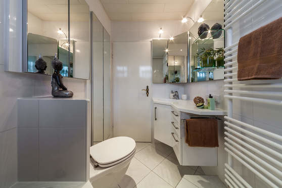 Immagine di una piccola stanza da bagno contemporanea con ante lisce, ante bianche, WC sospeso, piastrelle bianche, pareti bianche, lavabo integrato e pavimento bianco