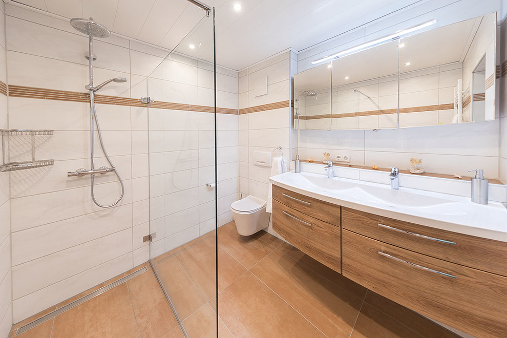 Bild på ett litet medelhavsstil badrum med dusch, med skåp i mörkt trä, en öppen dusch, en vägghängd toalettstol, vit kakel, keramikplattor, vita väggar, klinkergolv i keramik, ett fristående handfat, orange golv och med dusch som är öppen