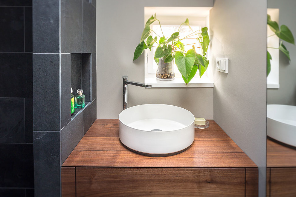 Kleines Modernes Duschbad mit dunklen Holzschränken, bodengleicher Dusche, grauer Wandfarbe, Schieferboden und Aufsatzwaschbecken in Berlin