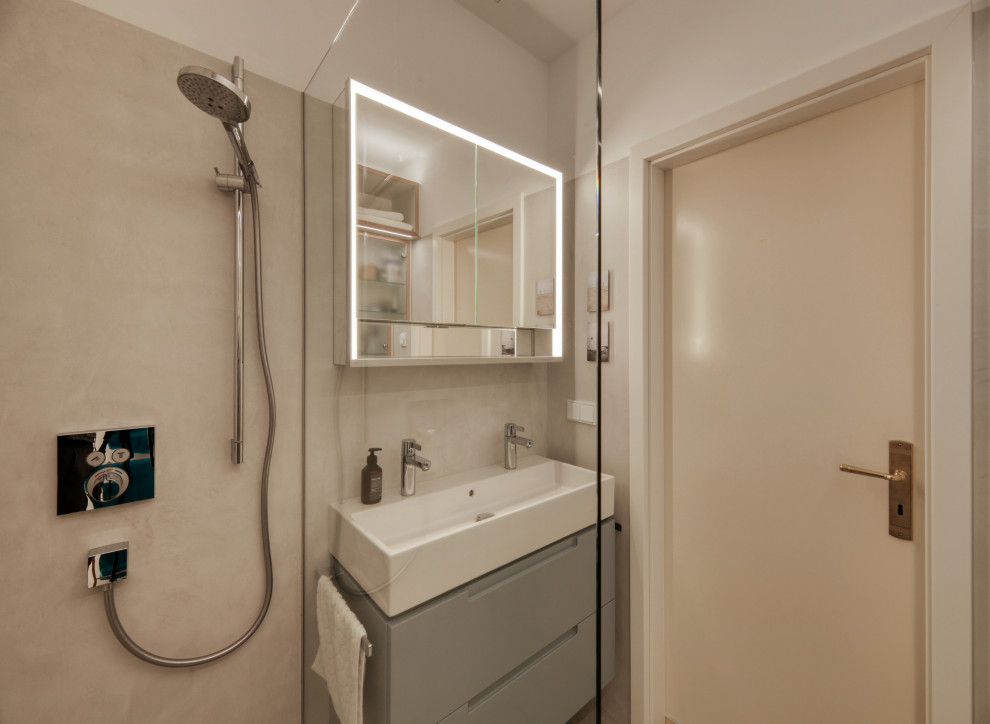 Cette image montre une petite salle d'eau design avec un placard à porte plane, des portes de placard bleues, une douche à l'italienne, un carrelage gris, un mur blanc, un lavabo suspendu, un sol gris, aucune cabine, une niche, meuble double vasque et meuble-lavabo suspendu.