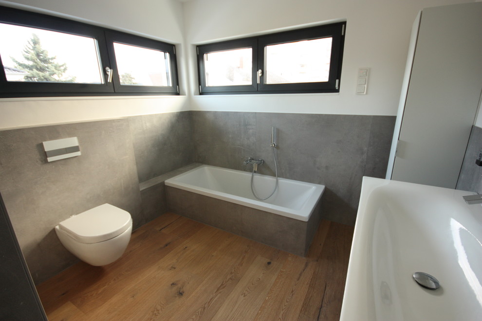 Inspiration för ett funkis badrum, med en kantlös dusch, grå kakel, bänkskiva i glas och grått golv