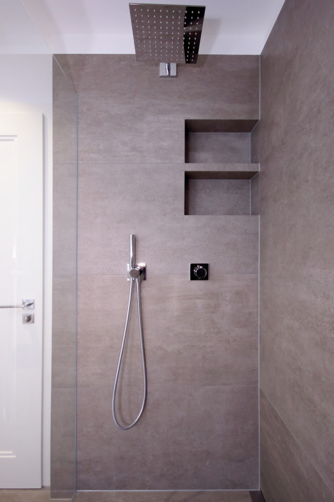 Inspiration för ett mycket stort funkis vit vitt badrum med dusch, med släta luckor, grå skåp, en dusch i en alkov, en vägghängd toalettstol, grå kakel, vita väggar, ett integrerad handfat, bänkskiva i akrylsten, grått golv och med dusch som är öppen