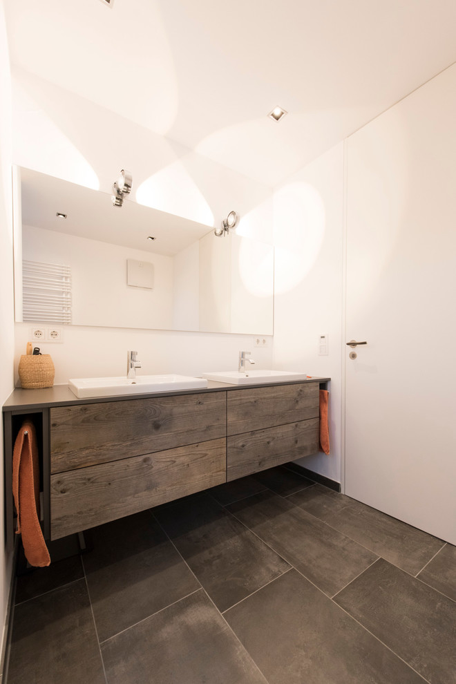 Diseño de cuarto de baño principal rústico de tamaño medio con armarios con paneles lisos, puertas de armario de madera en tonos medios, baldosas y/o azulejos grises, baldosas y/o azulejos de terracota, paredes blancas y lavabo encastrado