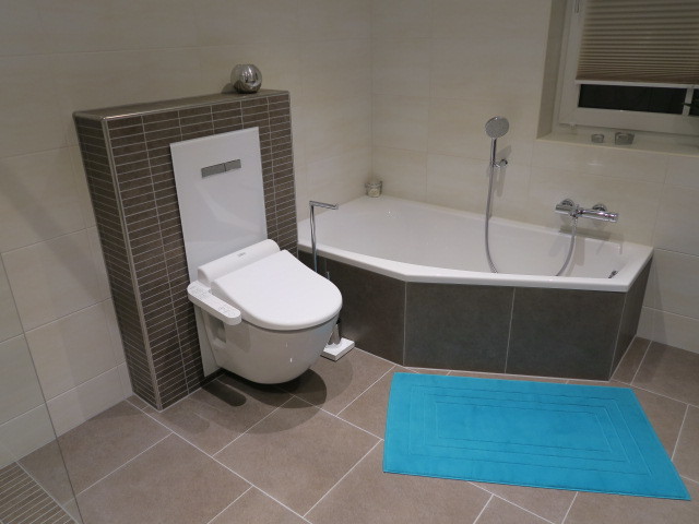 Aménagement d'une salle d'eau contemporaine de taille moyenne avec des portes de placard marrons, une baignoire posée, un carrelage marron, un sol en carrelage de céramique et un plan de toilette en surface solide.