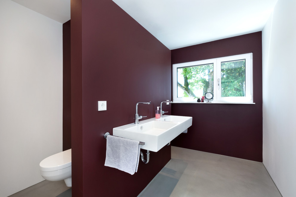 Пример оригинального дизайна: ванная комната среднего размера в современном стиле с открытым душем, раздельным унитазом, красными стенами, душевой кабиной, подвесной раковиной, серым полом и открытым душем