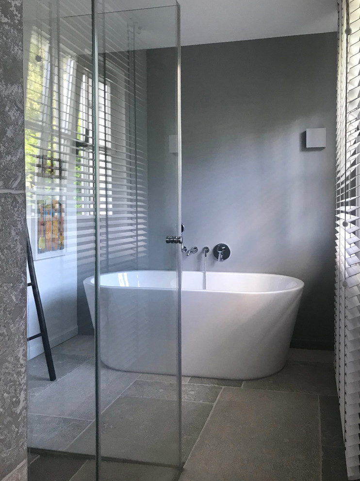 Esempio di una stanza da bagno con doccia moderna di medie dimensioni con vasca freestanding, doccia a filo pavimento, pareti grigie, pavimento grigio e porta doccia scorrevole