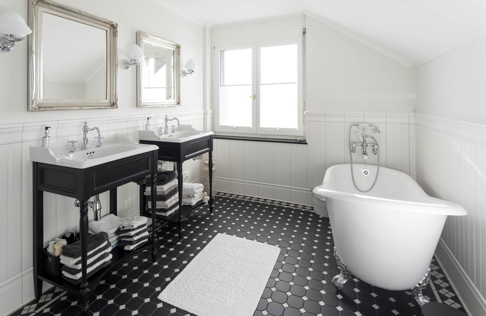 Klassisches Badezimmer mit freistehender Badewanne, weißen Fliesen, Kalkfliesen, Keramikboden, Trogwaschbecken und schwarzem Boden in Sonstige