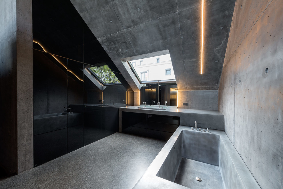 Esempio di una grande stanza da bagno industriale con vasca freestanding, pareti grigie, pavimento in vinile, top in cemento e pavimento grigio