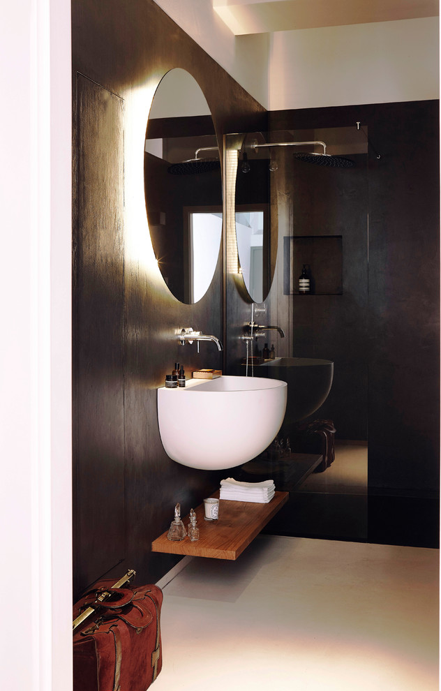 Exempel på ett litet 50 tals badrum med dusch, med öppna hyllor, bruna skåp, en kantlös dusch, svart kakel, cementkakel, vita väggar, betonggolv, ett väggmonterat handfat, vitt golv och med dusch som är öppen