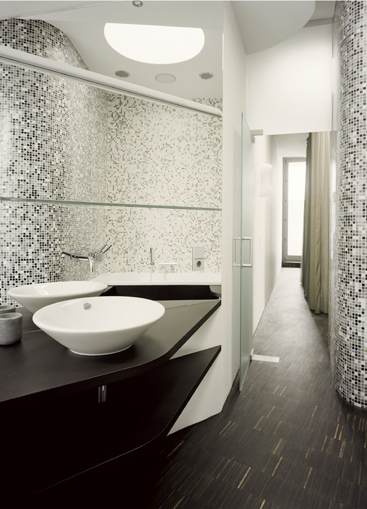 Idée de décoration pour une salle de bain design de taille moyenne avec un carrelage gris, un carrelage noir, un carrelage blanc, carrelage en métal, parquet foncé, une vasque et un plan de toilette en bois.