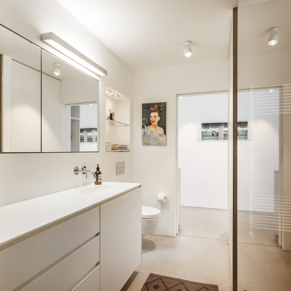 Mittelgroßes Modernes Badezimmer mit flächenbündigen Schrankfronten, weißen Schränken, Wandtoilette, weißer Wandfarbe, Einbauwaschbecken und beigem Boden in Hamburg