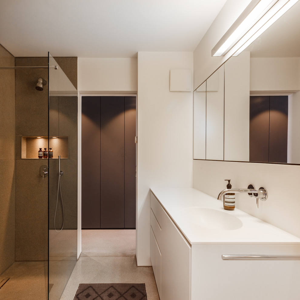 Ejemplo de cuarto de baño minimalista de tamaño medio con armarios con paneles lisos, puertas de armario blancas, ducha a ras de suelo, paredes blancas, lavabo sobreencimera y suelo beige