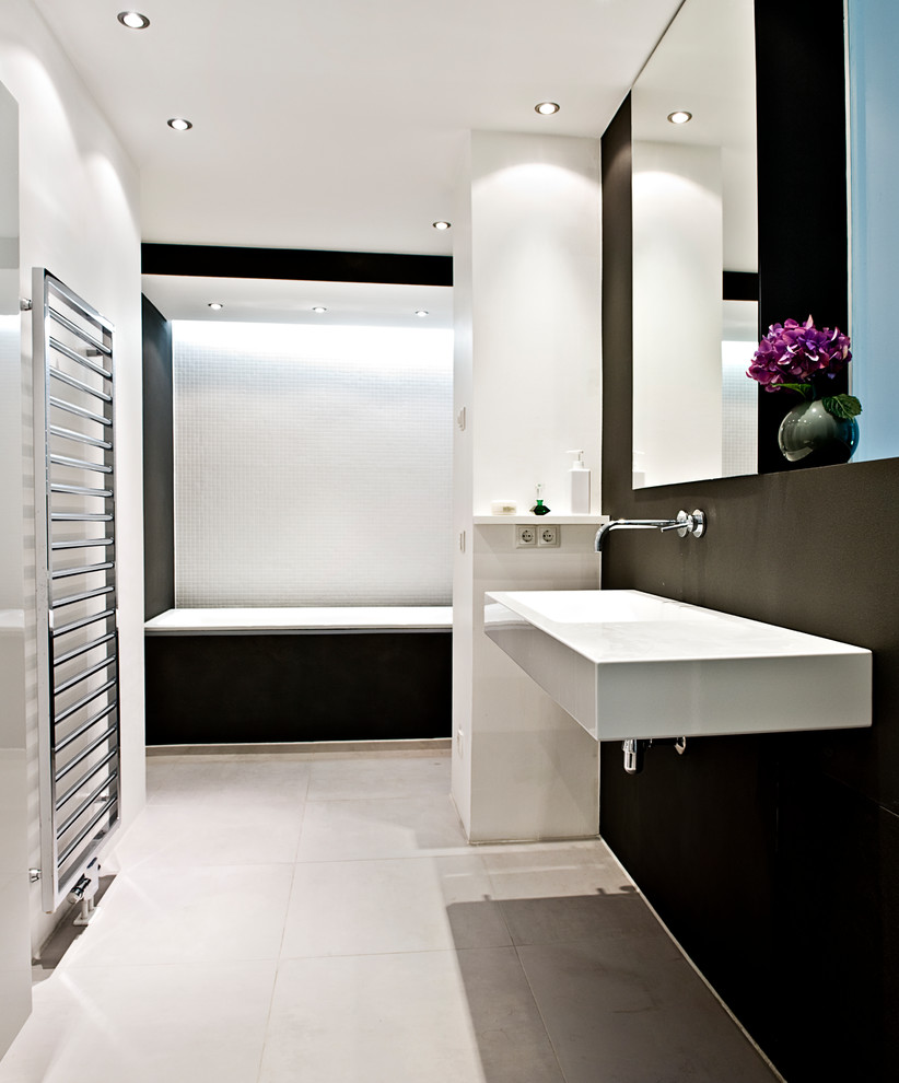 Réalisation d'une salle de bain design de taille moyenne avec une baignoire en alcôve, un mur noir, un sol en carrelage de céramique, un lavabo suspendu et un sol beige.
