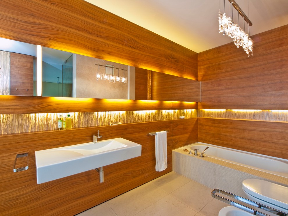 Cette image montre une salle de bain design de taille moyenne avec un lavabo suspendu, une baignoire posée, un carrelage beige, mosaïque et un sol en calcaire.