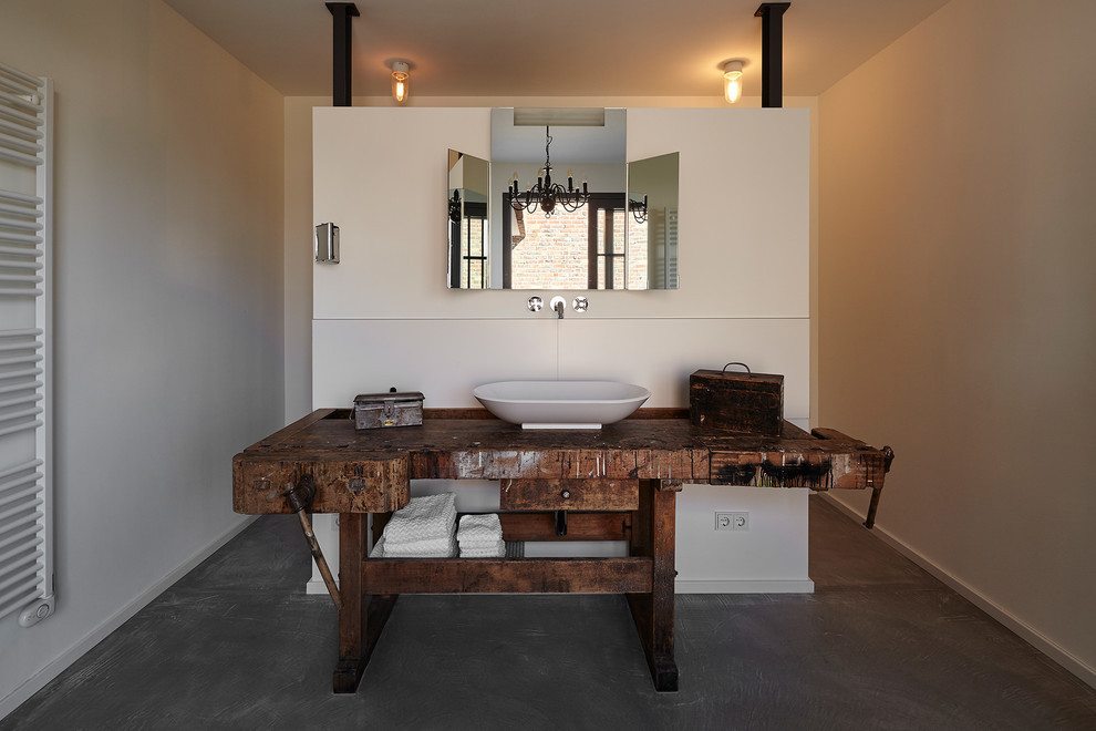 Industrial Badezimmer mit weißer Wandfarbe, Betonboden, Aufsatzwaschbecken, Waschtisch aus Holz und grauem Boden in Köln