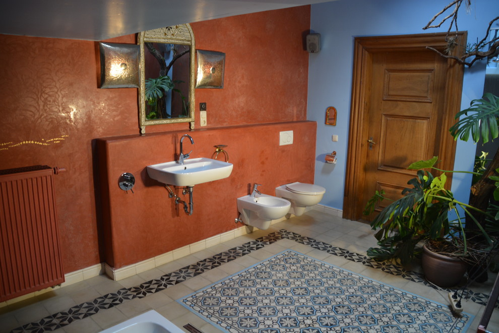Diseño de cuarto de baño mediterráneo extra grande con lavabo suspendido, ducha a ras de suelo, sanitario de pared, baldosas y/o azulejos de cemento, paredes azules, suelo con mosaicos de baldosas, baldosas y/o azulejos multicolor y bañera encastrada