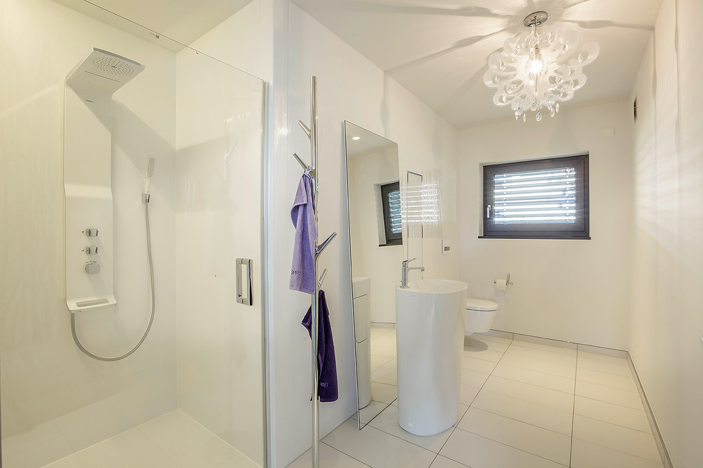 Идея дизайна: ванная комната среднего размера в современном стиле с инсталляцией, белой плиткой, белыми стенами и раковиной с пьедесталом