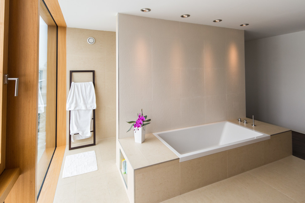 Modern inredning av ett stort badrum, med ett fristående handfat, ett platsbyggt badkar, en kantlös dusch, beige kakel, stenkakel, beige väggar och travertin golv