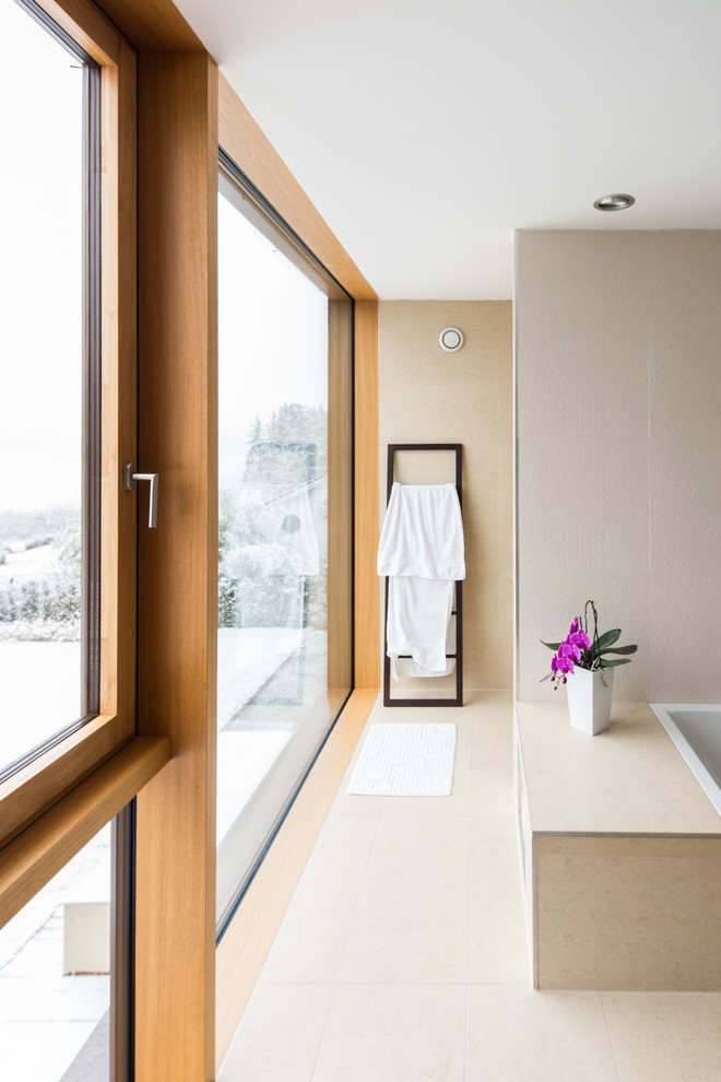 Idee per una stanza da bagno moderna con lavabo a bacinella, vasca da incasso, doccia a filo pavimento, piastrelle beige e piastrelle in pietra