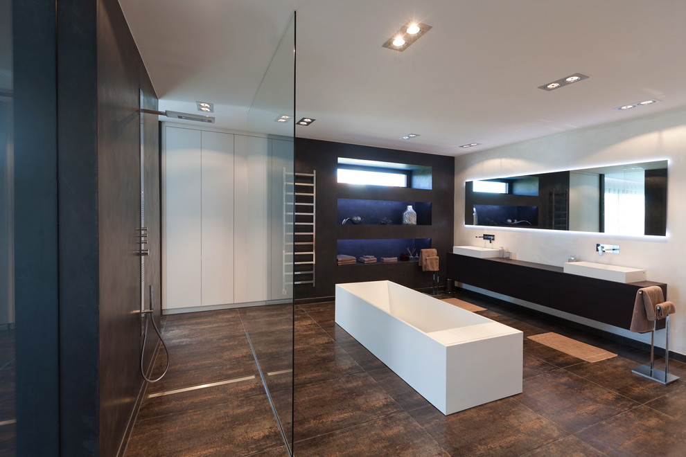Modern inredning av ett stort en-suite badrum, med ett fristående handfat, öppna hyllor, svarta skåp, ett fristående badkar, vita väggar och en kantlös dusch