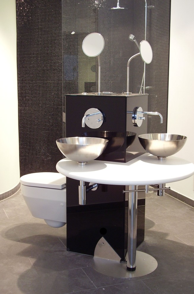 Foto på ett litet funkis badrum med dusch, med våtrum, en vägghängd toalettstol, svart kakel, mosaik, vita väggar, cementgolv, ett fristående handfat, grått golv och med dusch som är öppen