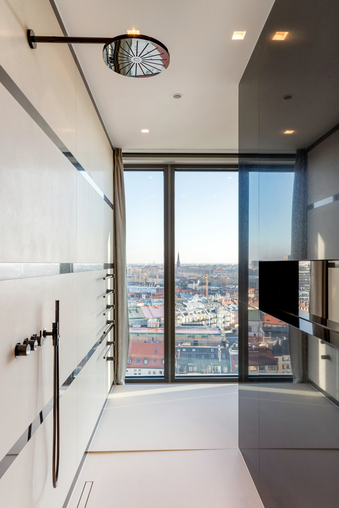Exemple d'une grande salle de bain principale tendance avec un placard à porte plane, des portes de placard noires, une baignoire posée, un carrelage beige, un lavabo intégré, un sol blanc et un plan de toilette noir.
