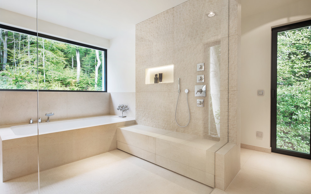 Modelo de cuarto de baño actual con bañera encastrada, paredes blancas y suelo beige