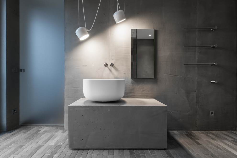 Immagine di una stanza da bagno minimalista con pareti grigie, lavabo a bacinella, top in superficie solida e top grigio