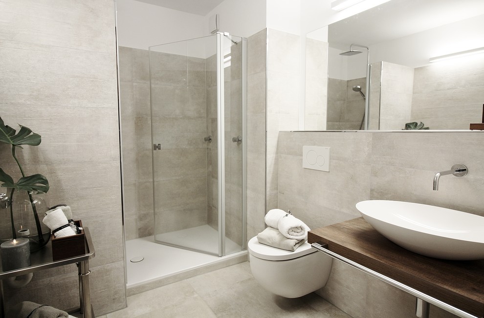 Inspiration för ett litet funkis brun brunt badrum med dusch, med en kantlös dusch, en vägghängd toalettstol, beige kakel, vita väggar, ett fristående handfat och bänkskiva i akrylsten
