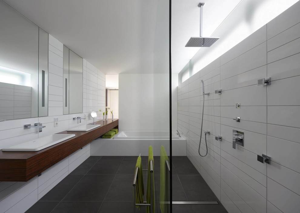 Réalisation d'une grande salle de bain design avec une douche ouverte, une baignoire posée, un carrelage blanc, des carreaux de céramique, un mur blanc, un sol en ardoise, un lavabo posé, un plan de toilette en bois et aucune cabine.
