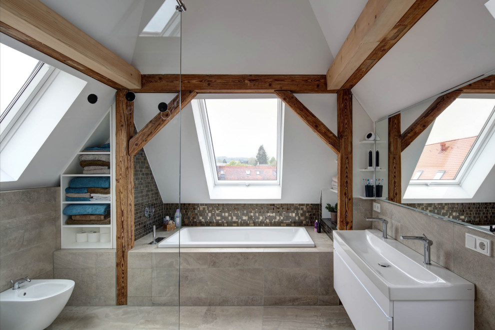 Cette photo montre une salle de bain tendance avec un placard sans porte, des portes de placard blanches, une baignoire posée, une douche à l'italienne, WC séparés, un carrelage gris, un mur gris, une vasque, un sol gris et aucune cabine.