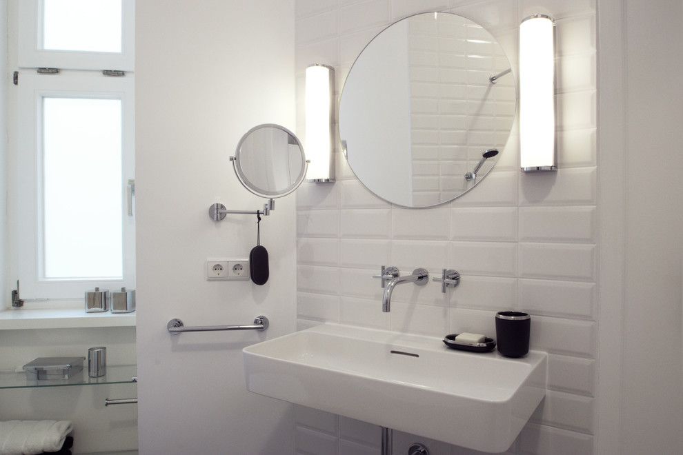 Идея дизайна: маленькая ванная комната в стиле модернизм с плоскими фасадами, белыми фасадами, отдельно стоящей ванной, душем над ванной, инсталляцией, белой плиткой, керамической плиткой, белыми стенами, подвесной раковиной, серым полом и шторкой для ванной для на участке и в саду