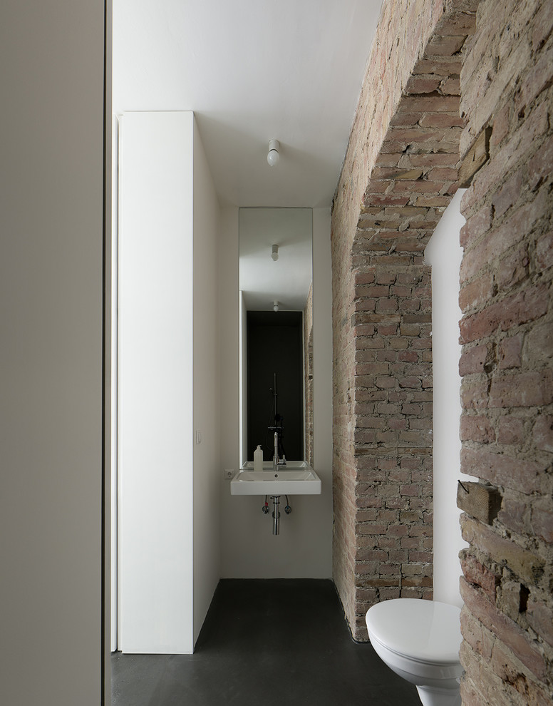 Foto de cuarto de baño rural pequeño con lavabo suspendido, sanitario de pared, paredes blancas y piedra