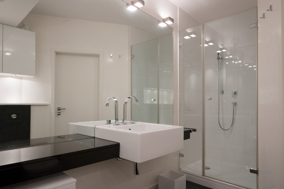 Свежая идея для дизайна: ванная комната в современном стиле с душем в нише, душевой кабиной, инсталляцией, белой плиткой, белыми стенами и черным полом - отличное фото интерьера