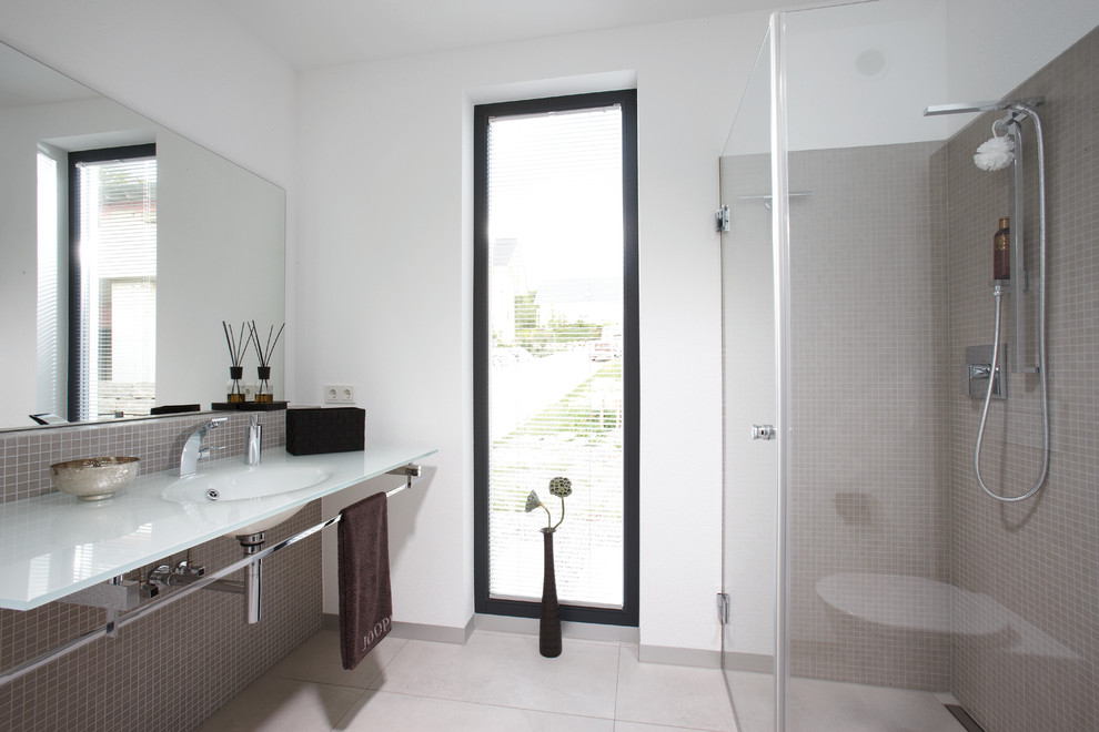 Inspiration for a medium sized modern bathroom in Other with a corner shower, grey tiles, mosaic tiles, white walls, an integrated sink and glass worktops.
