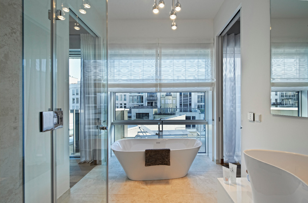 Cette image montre une grande salle de bain design avec une baignoire indépendante, un mur blanc et une vasque.