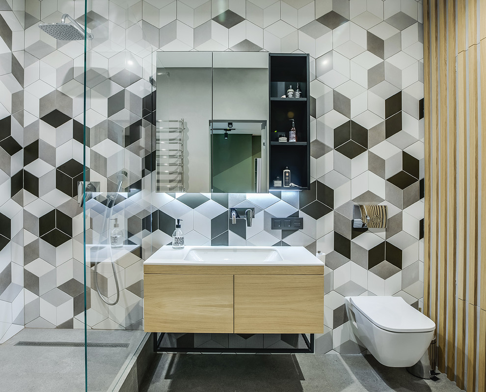 Design ideas for a contemporary ensuite bathroom in Other with flat-panel cabinets, light wood cabinets, a walk-in shower, a wall mounted toilet, grey tiles, white tiles, white walls, concrete flooring, a submerged sink, grey floors, an open shower and white worktops.